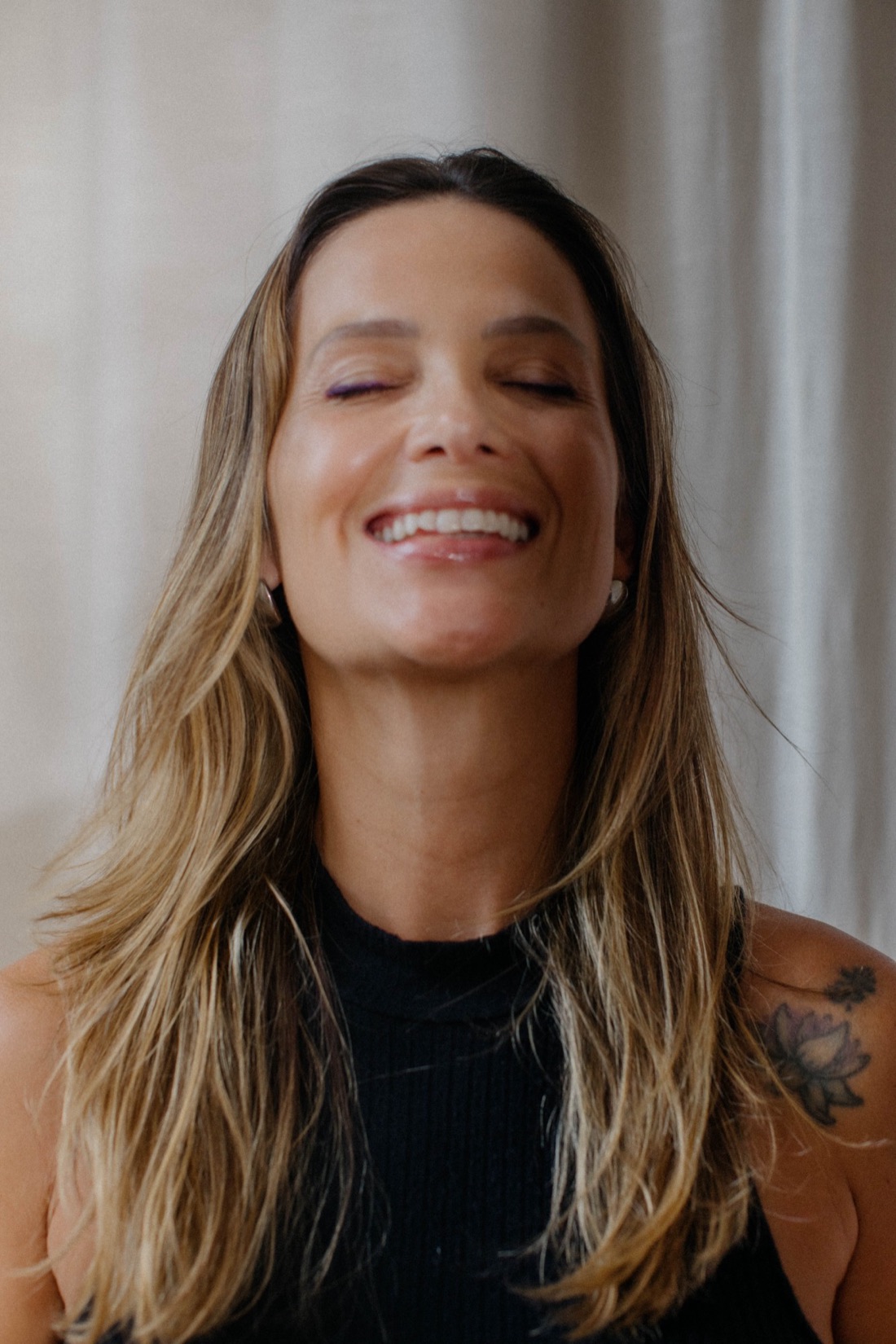 Manuela Vitiello, mentora executiva e criadora da mentoria Fluir, sorrindo de olhos fechados